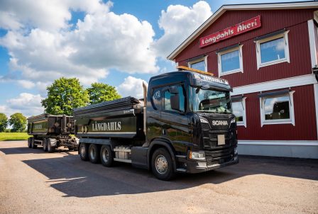 svart lastbil med släp transporterar grus för Långdahls åkeri