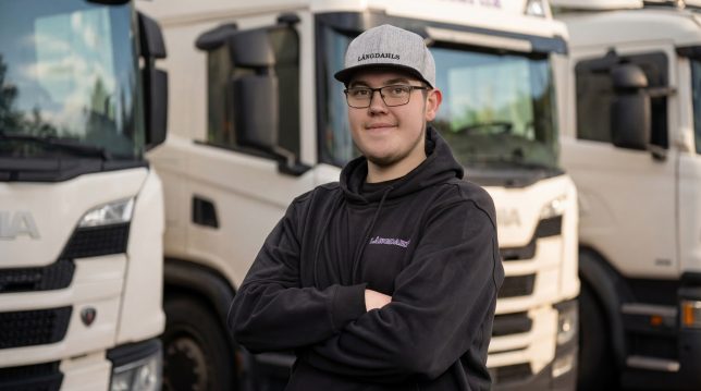 En chaufför för Långdahls står framför flera lastbilar.